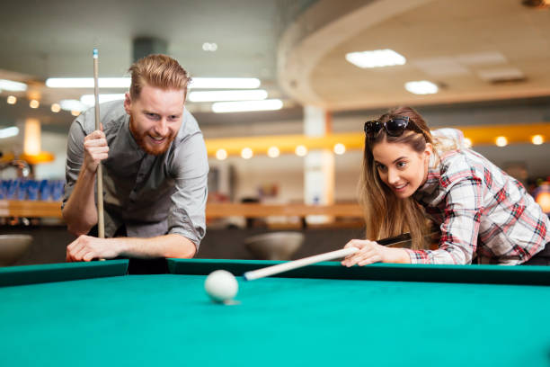 istock Beautiful couple flirting while playing snooker 663109726