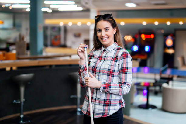 Beautiful brunette chalking billiard cue Beautiful brunette chalking billiard cue pool cue stock pictures, royalty-free photos & images