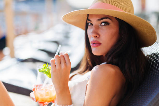 istock Seductive woman drinking cocktail and sunbathing 663121062