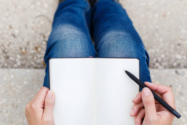 istock Top view of young woman making notes in notebook 663125000