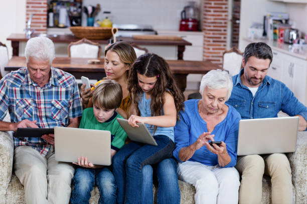 famiglia multigenerazione che utilizza laptop, tablet e telefono - grandparent family multi generation family technology foto e immagini stock