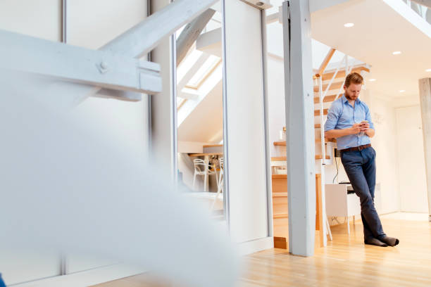 istock Handsome business at home holding phone and calling colleague after work 663136570