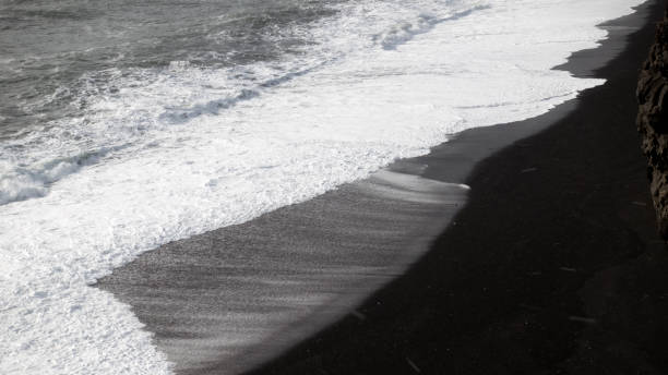 istock Foamy water over the black sand beach 663150296