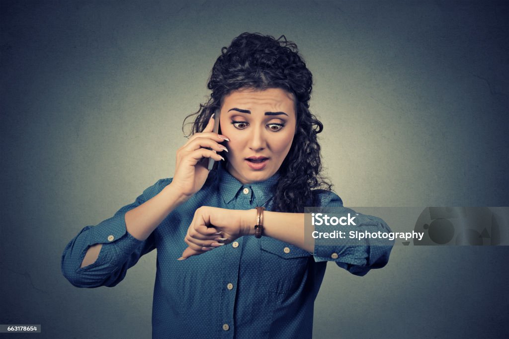 Stressed businesswoman looking at wrist watch Business and time management concept. Stressed businesswoman looking at wrist watch, running late for meeting Adult Stock Photo