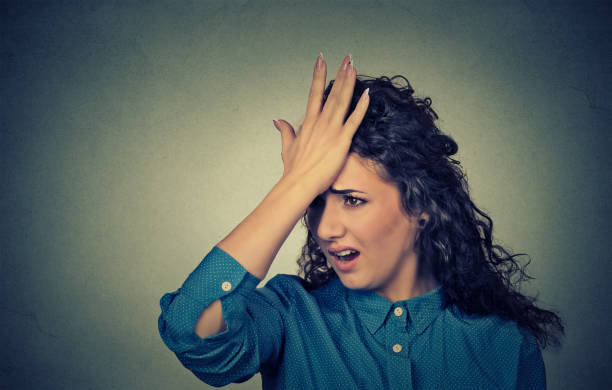 istock silly young woman, slapping hand on head having duh moment 663181318