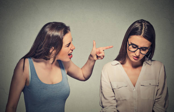 Girl patronizing screaming pointing finger Bullying, friendship and people concept. Girl patronizing screaming pointing finger at shy timid nerdy woman who is looking down bad friendship stock pictures, royalty-free photos & images