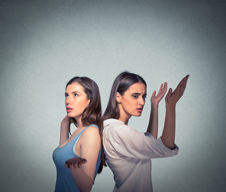 Closeup portrait of two women back to back putting hands in air looking up in frustration, isolated on gray background. Negative human emotion facial expression feelings. Miscommunication conflict