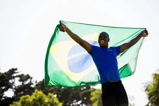 Athlete posing with brazilian flag after victory in stadium
