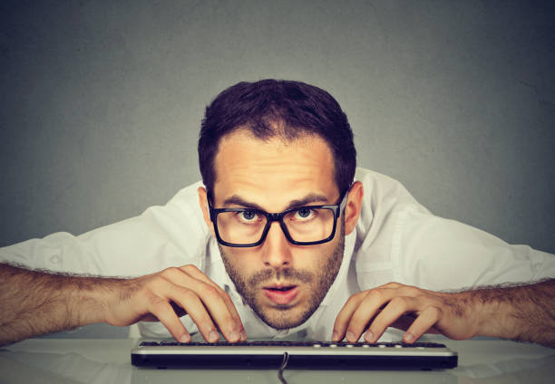 istock Crazy looking nerdy man typing on the keyboard 663198524