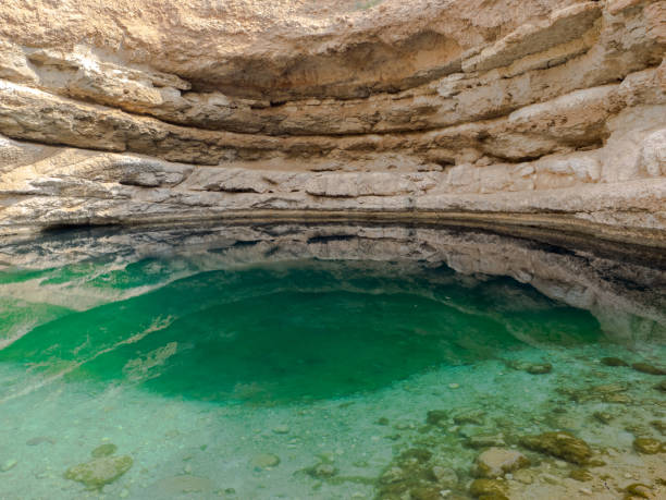 бимма воронка, геологическая депрессия в известняке в омане - natural phenomenon hawiyat najm park cliff cave стоковые фото и изображения