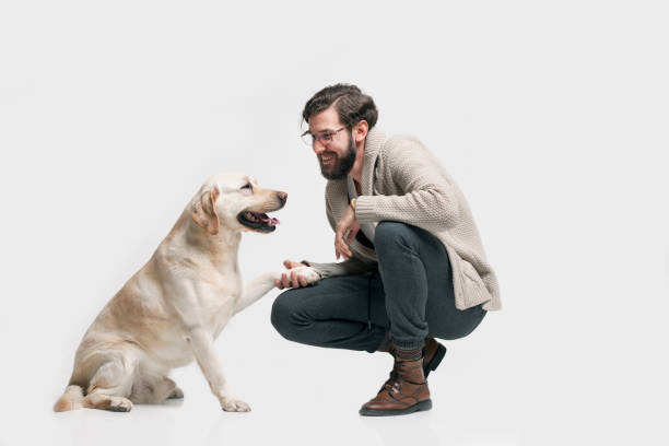 Adult man in blue sport clothes lying with his old injured dog on the ground in forest.
