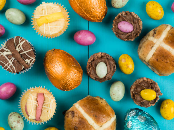 Selection of Traditional Easter Cakes and Mini Chocolate Easter Eggs Against a Blue Background Selection of Traditional Easter Cakes and Mini Chocolate Easter Eggs Against a Blue Background easter sunday photos stock pictures, royalty-free photos & images