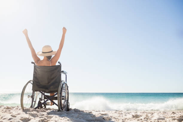 Wheelchair woman sitting  with arms up stock photo