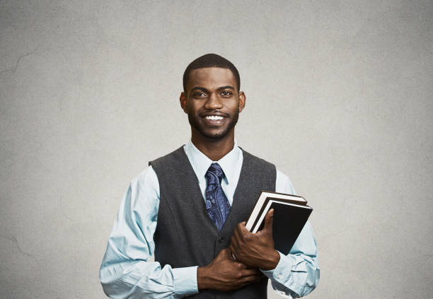 istock young smart, happy, smiling handsome man holding books, 663279236