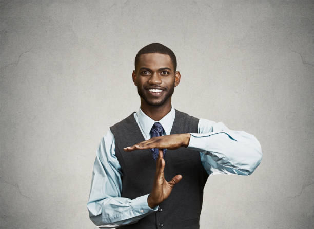 istock young, happy, smiling, executive company man showing time out gesture 663280070