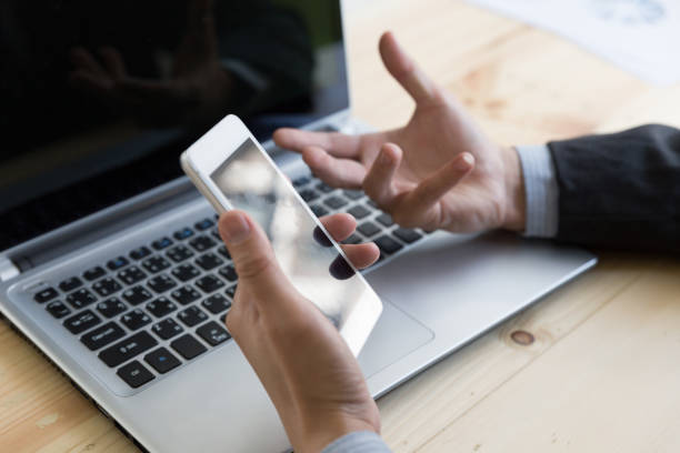 istock Businessman using smartphone and laptop computer in office 663281316
