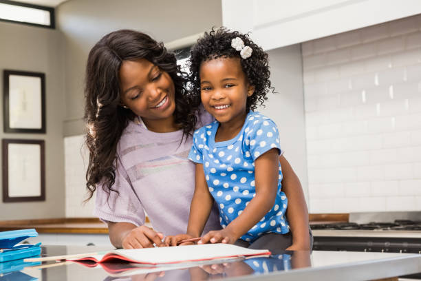 istock Young girl doing her homework with her mother 663300700