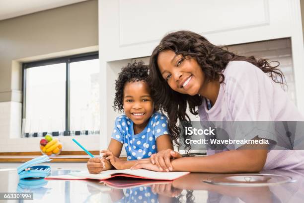 Young Girl Doing Her Homework With Her Mother Stock Photo - Download Image Now - 20-29 Years, 25-29 Years, 4-5 Years