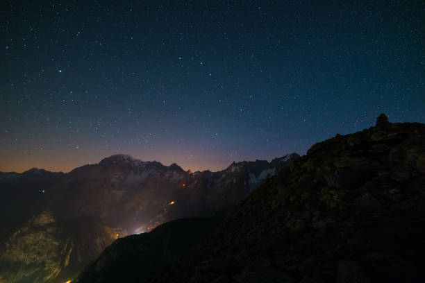 Stunning night view of Mont Blanc peak (4810 m) Stunning night view of Mont Blanc peak (4810 m) with breathtaking starry sky above and the glowing cable car up to P. Helbronner. Wide angle view from 3000 m. 4810 stock pictures, royalty-free photos & images