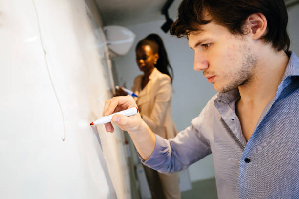 istock Smart people writing on whiteboard in search of a solution 663303138