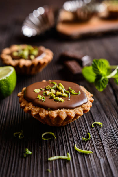 istock Tartlets with chocolate, pistachios and lime peel 663333682