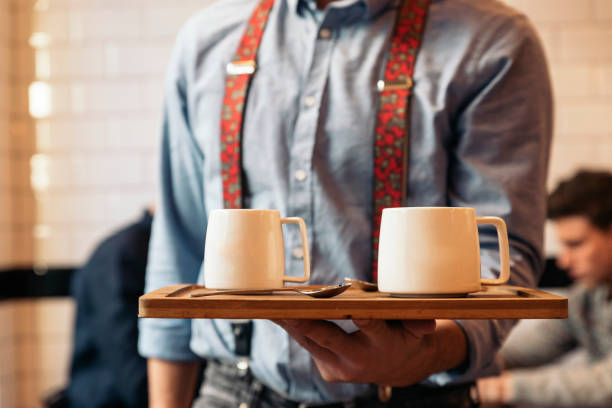 istock Waiter holding a tray with coffees. 663353070