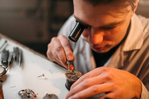 istock Watchmaker with loupe repair clockwork mechanism 663359096