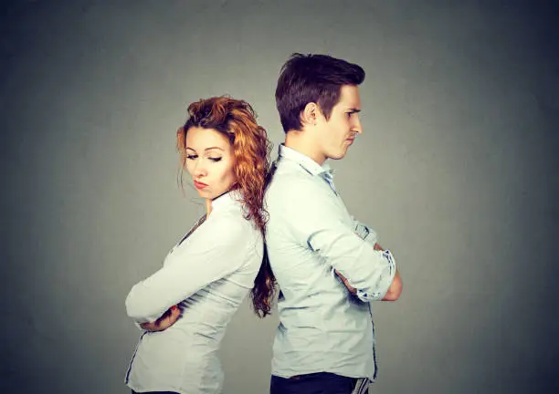 Photo of Angry frustrated young couple standing back to back