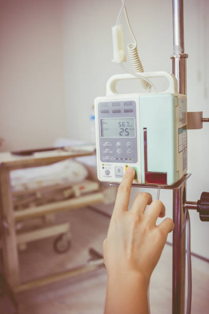 istock Nurse's hands regulation infusion pump intravenous IV drip. 663373232
