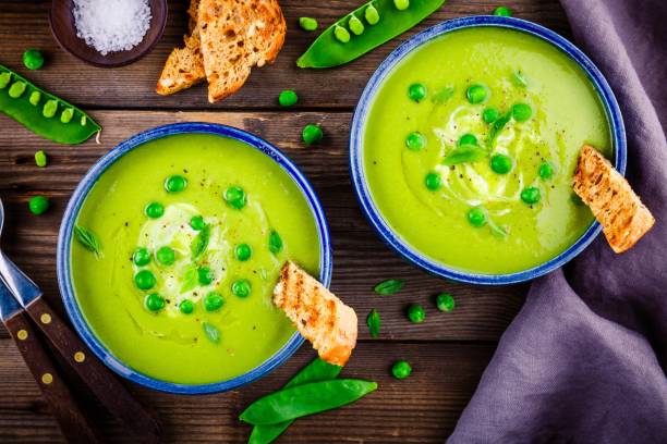 istock Green pea soup on wooden rustic background 663381700