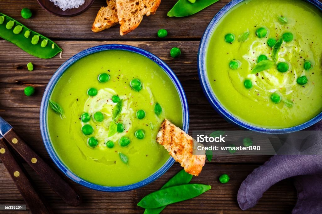 Green pea soup on wooden rustic background Green pea soup with croutons on wooden rustic background Green Pea Stock Photo