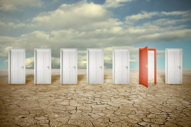 istock Red opened door among many closed white ones 663390604