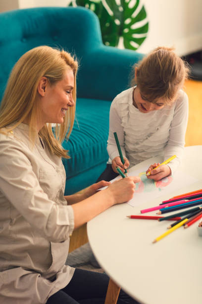 istock Pregnant Mother and her daughter drawing 663393528