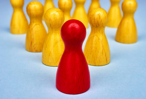 istock Symbol for leadership with game figures in yellow and red 663453804