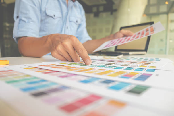 istock Graphic design and color swatches and pens on a desk. Architectural drawing with work tools and accessories. 663467080