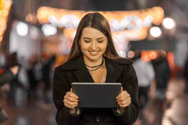 istock Beautiful young woman using digital tablet by night 663481408