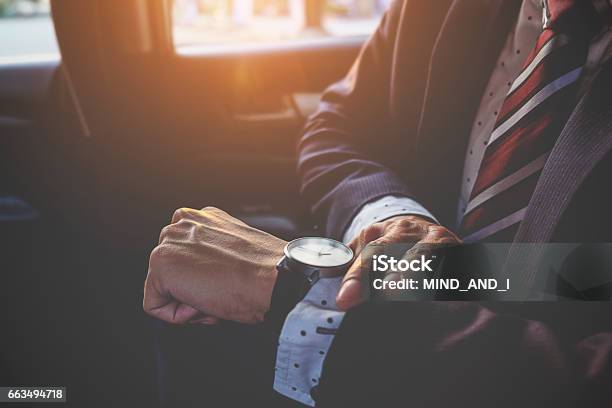 Businessman Looking At The Time On His Wrist Watch In Car Business Concept Stock Photo - Download Image Now