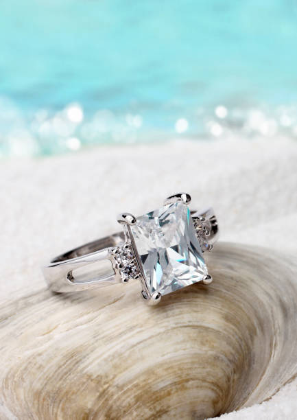 istock Jewelry ring with diamond on sand beach background, soft focus 663522280