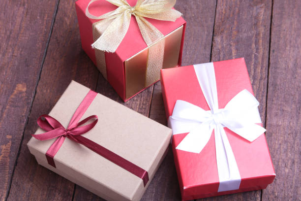 istock red and gold gift box on wood background. 663540874