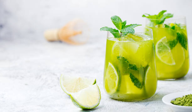 abbina un tè verde freddo con lime e menta fresca su sfondo marmoreo. spazio di copia - hot drink alcohol green glass foto e immagini stock