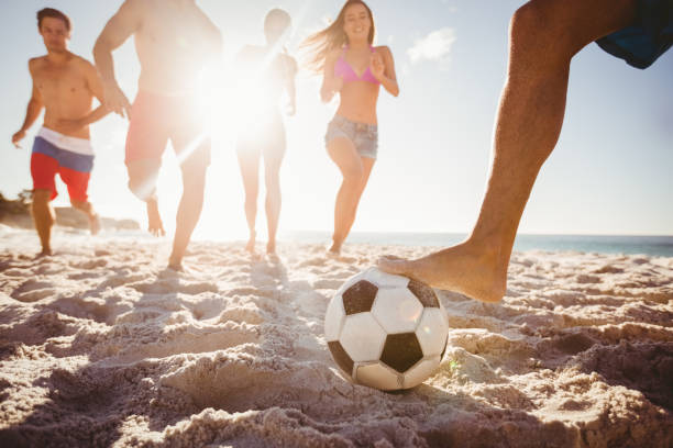 friends playing football - beach football imagens e fotografias de stock
