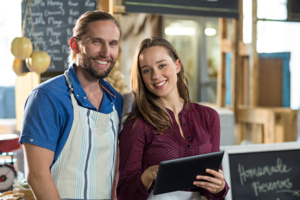 istock Portrait of smiling bakery staff using digital tablet at counter 663597474