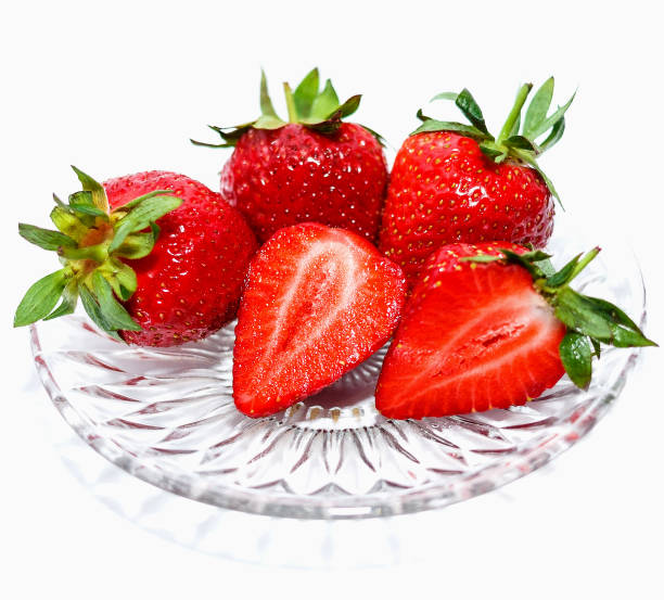 istock Fresh red strawberries in a glass dish with isolation on a white background 663605052