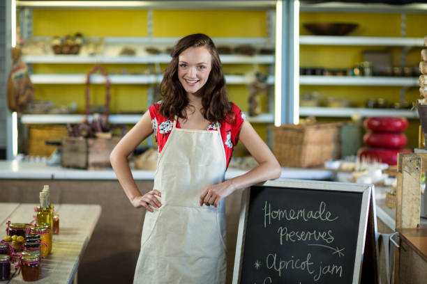 istock Female shop assistant standing besides menu chalk board 663614550
