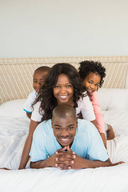 istock Happy family lying on bed 663624068