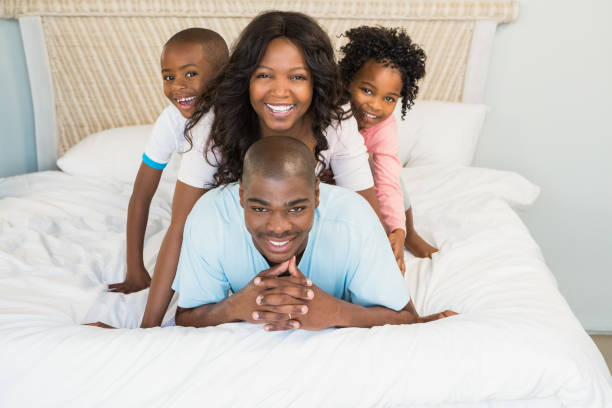 istock Happy family lying on bed 663624326