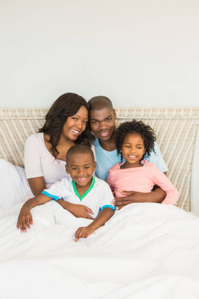 istock Happy family lying on bed 663632528