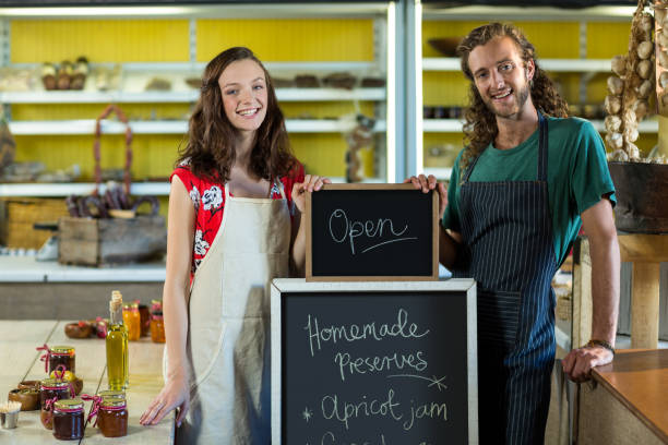 istock shop assistants holding open sign board 663634276