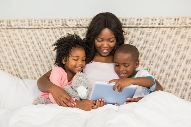 istock Happy family using tablet in bed 663650880