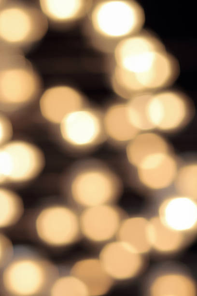 istock golden bokeh on a black background, abstract dark backdrop with defocused warm lights 663654602